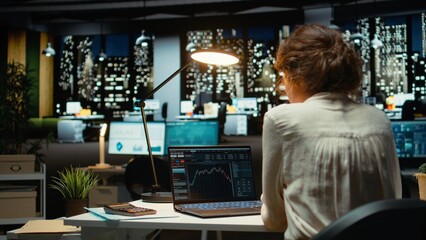 Employee monitors live stock market trends and cryptocurrency exchanges, leveraging technology and...