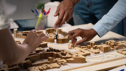 Close up of engineers team creating the property layout for site preparation, using 3D models for urban development and construction project. Infrastructure growth and city planning.