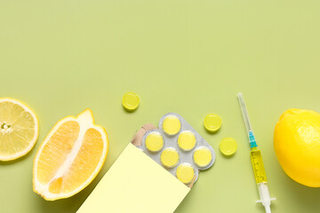 Cough drops in blister with lemon and syringe on green background