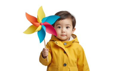 A young boy holding a colorful pinwheel on transparent background