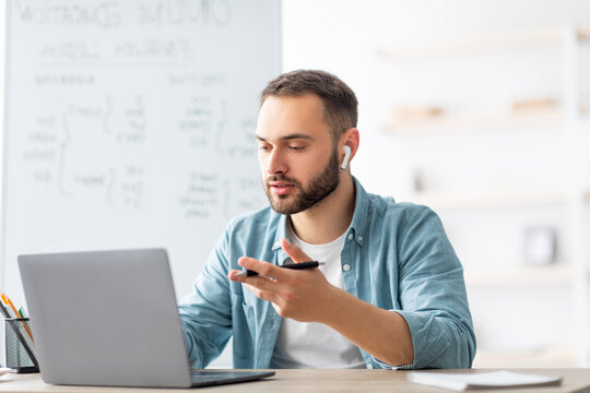 Learning English online. Focused male teacher giving foreign language lesson on web using laptop. Millennial tutor explaining grammar rules to students on internet during covid lockdown