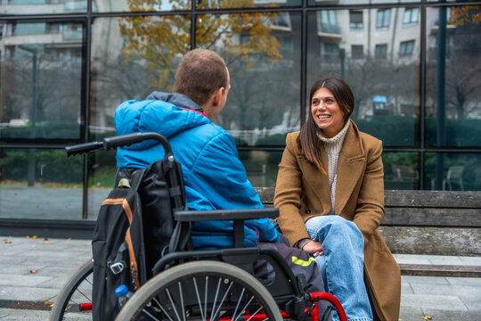 Disabled man and woman having an inclusive conversation outdoors - Powered by Adobe