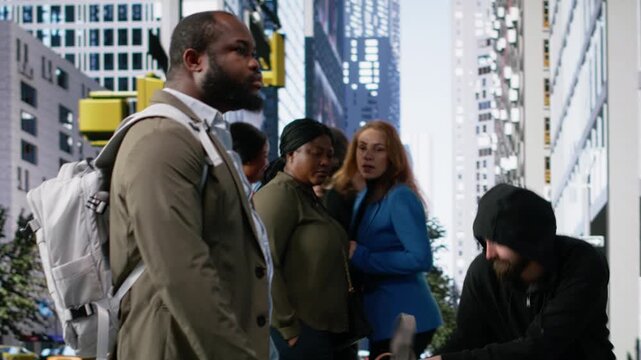Theft in downtown street as a man grabs handbag from gen z female victim, bystanders remain passive ignoring the illegal wrongdoing in a big city. Street crime and vulnerability. Camera B.