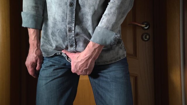 Unrecognizable middle-aged man scratching his crotch due to itching and discomfort in the groin area. 4K