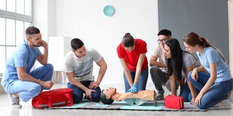 Instructor demonstrating CPR on mannequin at first aid training course