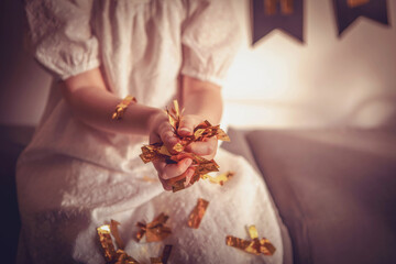 Happy little girl celebrating birthday with colorful confetti