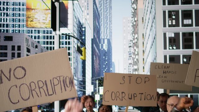 Protesters gather in rally against corrupted government and scandalous politics, holding cardboard posters and banners with angry warning messages focused on democracy and anti-corruption. Camera A.