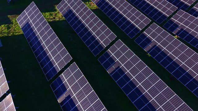Rows of solar panels are placed on a field, capturing sunlight during the day. The setup highlights renewable energy sources in use.
