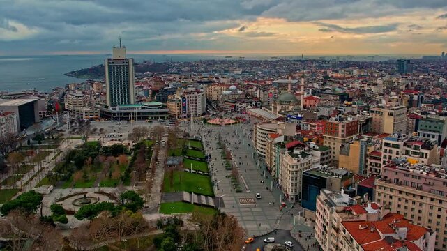 Drone footage showing Taksim Square, Gezi Park, The Marmara Hotel, the Bosphorus and Istanbul skyline under dramatic evening clouds and soft sunset light.