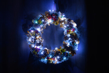 decorative wreath with lighting and toys on a blue background