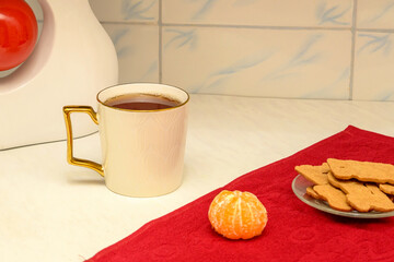 cup of tea with cookies and tangerine on the kitchen table