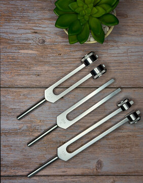 Set of Tuning Forks for Sound Therapy and Healing on Wooden Surface
