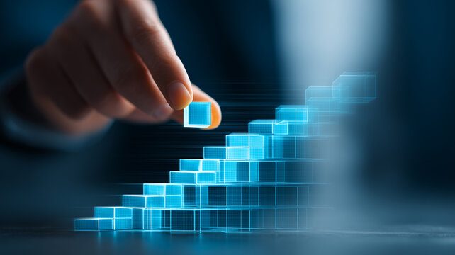 A hand arranging transparent digital blocks into an ascending structure, representing scalable technology growth and digital transformation.
