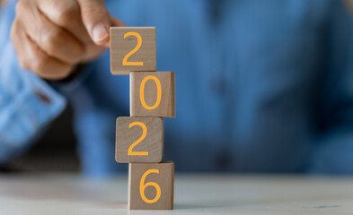 Hand arranging wood block stacking with number 2026, Concept for business planning strategy, new year resolution, financial growth, target goal setting and future success development steps