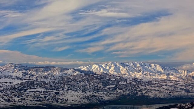 A cinematic aerial view of a river winding through snowy mountains and a wide winter valley. Perfect for nature, winter landscapes, geography visuals and cinematic drone footage.