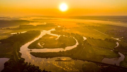 Aerial View of River Meandering Through Landscape at Sunrise.