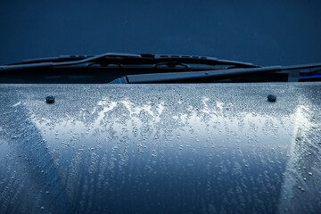 Wet car with drops of water on the windshield, closeup