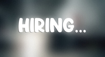 A hiring sign with glowing white text on a dark background with spotlight effect with job and employment and career and recruitment and job opening and employment opportunity