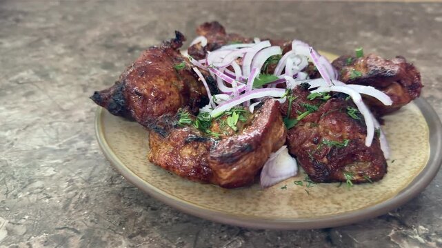 crispy grilled chicken wings on plate, topped with thinly sliced red onion and parsley, charred edges glazed with smoky marinade, rustic stone surface, closeup foodporn shot