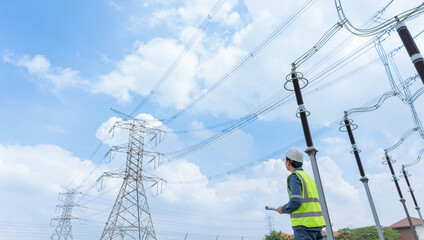 Engineer inspecting high voltage transmission lines inside electrical substation yard, ensuring power grid reliability, safety compliance, and infrastructure monitoring. © JD Studio