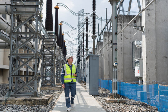 Electrical engineer walking through high voltage power substation while inspecting equipment, supporting routine maintenance, safety compliance, and reliable electricity distribution.
