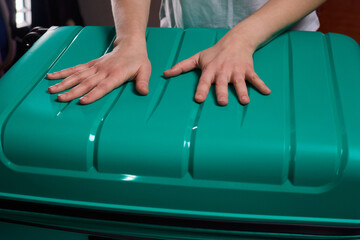 Traveler opening luggage, Close shot of hands unfastening suitcase zipper before travel, Detailed...