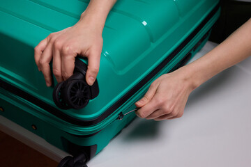 Traveler opening luggage, Close shot of hands unfastening suitcase zipper before travel, Detailed...