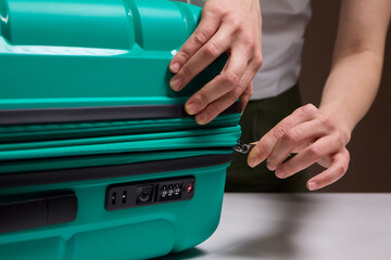 Traveler opening luggage, Close shot of hands unfastening suitcase zipper before travel, Detailed...