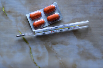 thermometer and pills on the table