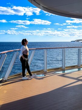 Woman on cruise ship deck overlooking the ocean