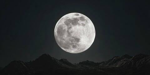 A full moon glows brightly over dark mountain silhouettes against a starless night sky