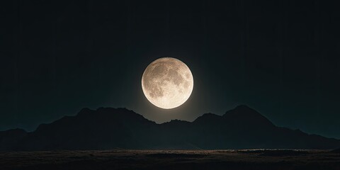 A bright full moon glows above dark mountain silhouettes at night