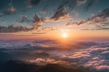 Aerial view of mountainous landscape, illuminated by a vibrant sunrise over clouds