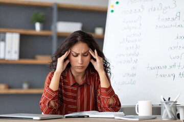 Tired From Work. Portrait of exhausted stressed young woman suffering from headache, touching and...