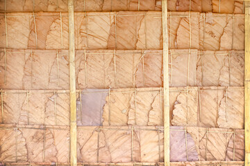 Autumn brown dry leaf patterns hanging with bamboo wood rustic wall natural cottage background