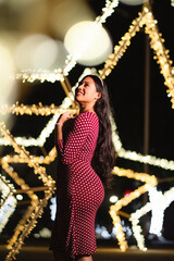 Elegant hispanic woman enjoying festive night lights