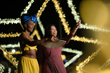 Diverse women friends enjoying night out pointing upwards