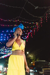 African caribbean woman networking on phone enjoying nightlife
