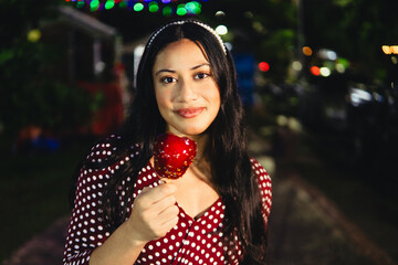 Woman enjoying sweet candied apple at night