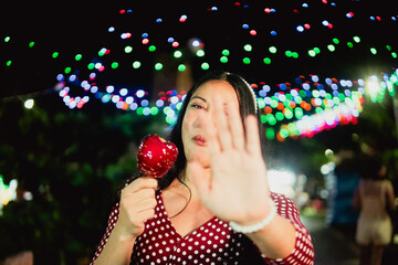 Woman enjoying candied apple at night event