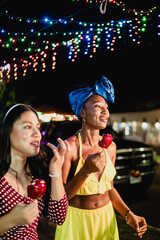 Diverse friends enjoying candy apples under festive lights