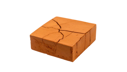 Weathered, cracked brown clay brick isolated on black background