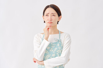 エプロンを着た女性　悩む　白背景
