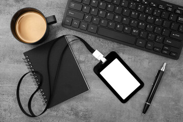 Black plastic badge with keyboard and coffee on stone texture background. Template designed for employees of company