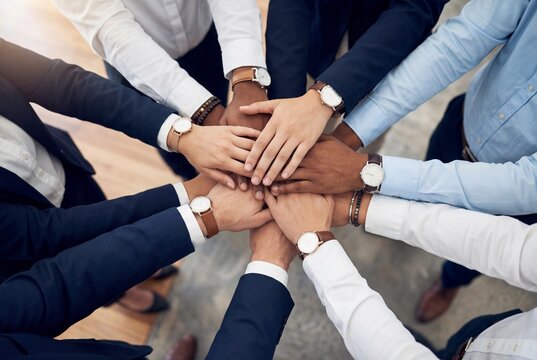 Diverse business team hands stacked together showing unity and collaboration