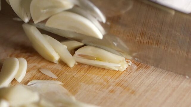 Cooking tips for slicing garlic on a wooden board