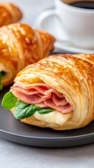 Croissant sandwich with ham, cheese, and spinach