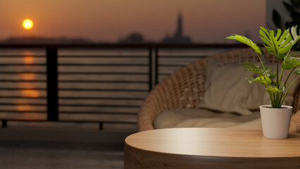 Naklejka premium Potted plant on round wooden table and woven sofa chair at balcony or rooftop and sunset above river