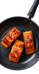 Pan-fried salmon fillets, three pieces, glistening with sauce, in black frying pan