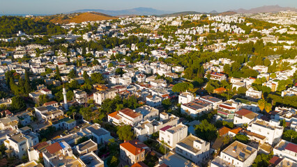 Bodrum, Turkey. Aerial drone flight over traditional white houses with flat roofs and green trees in Bodrum residential neighborhood.. Aerial View
